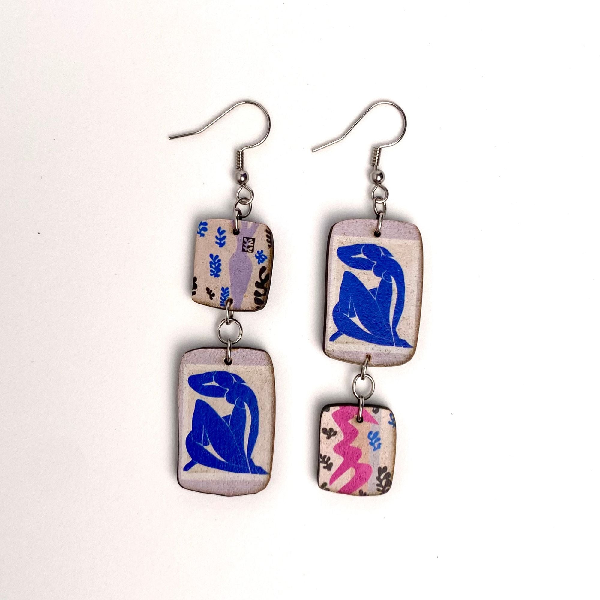 Pair of earrings with abstract Mattise Blue Nude designs on a white background