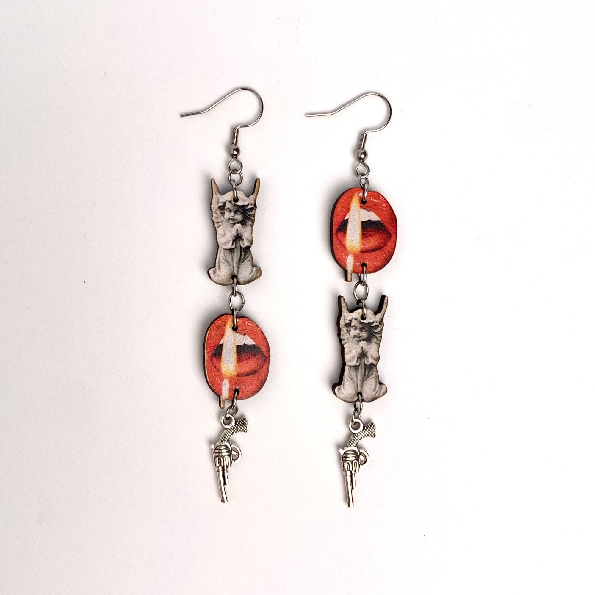 Pair of earrings, lips with flame, a statue of a cherub, a mini gun