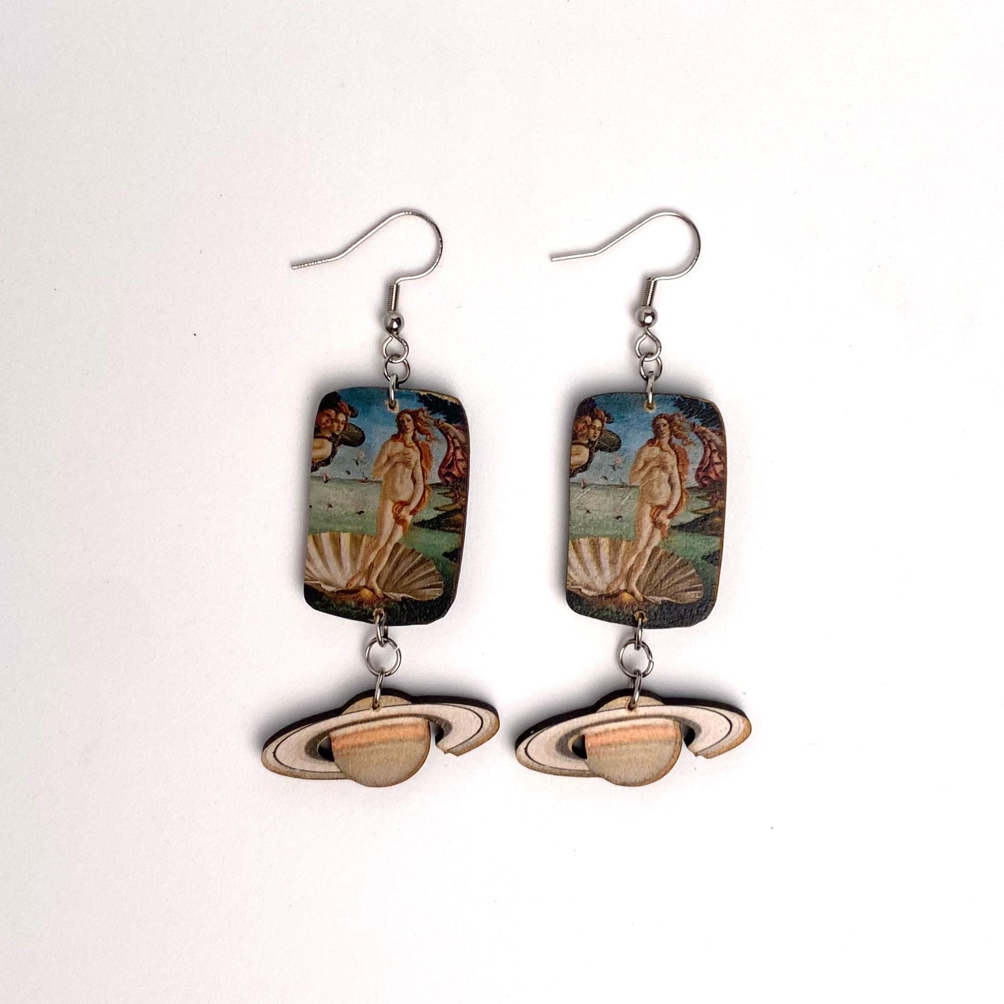 Pair of earrings with classical painting design and Saturn symbol on a white background